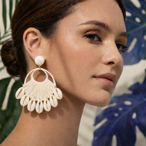These lightweight white raffia earrings frame the face beautifully with their bold texture and organic shell accents, making them an ideal accessory for a beachside wedding or a sunset dinner on vacation.