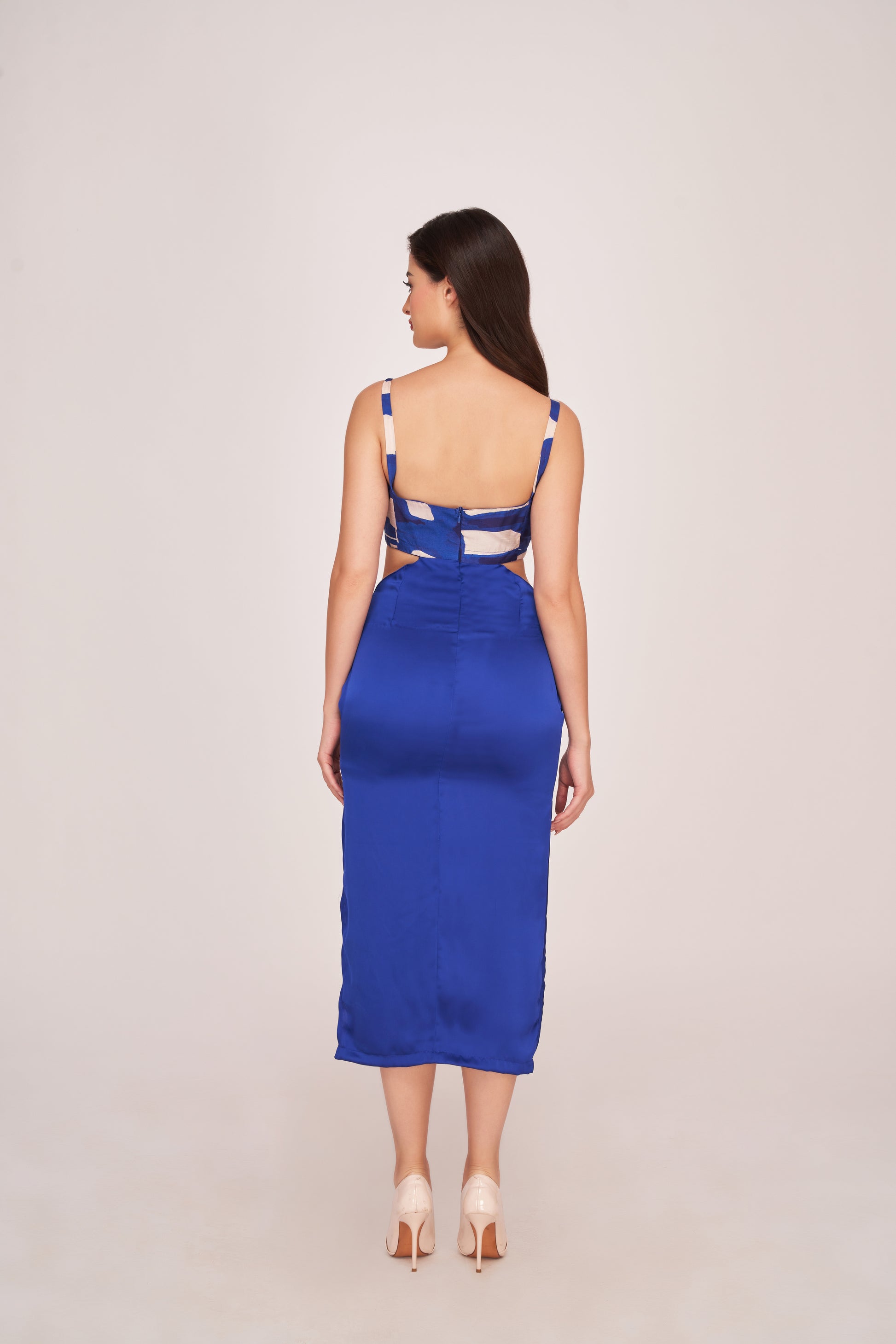 Rear studio view of model wearing blue satin dress, displaying back zip and shoulder straps.
