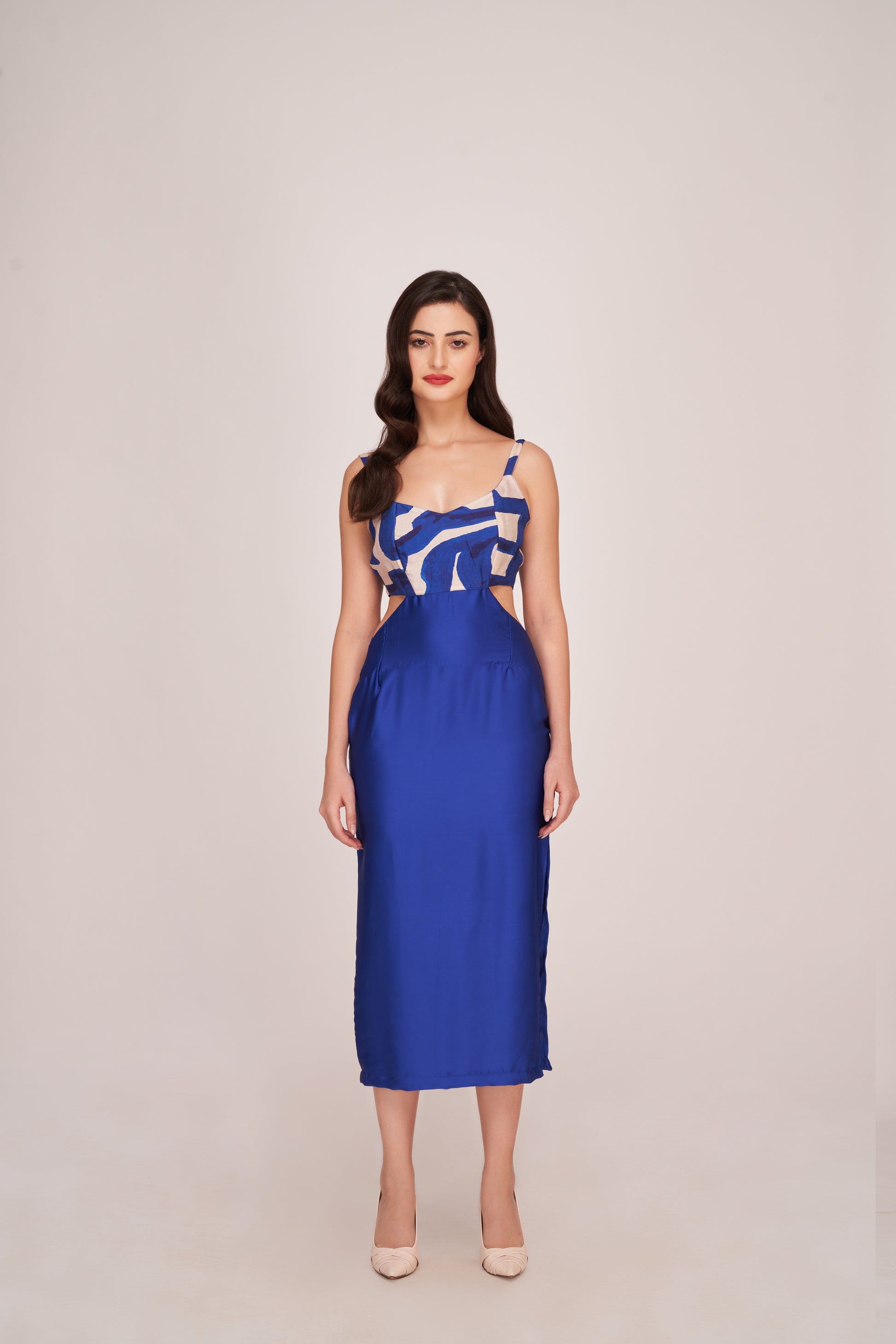 Model in royal blue satin midi dress with abstract white print, posing front-facing in studio.