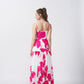 Rear view of the full-length floral dress with spaghetti straps and flowing hemline.