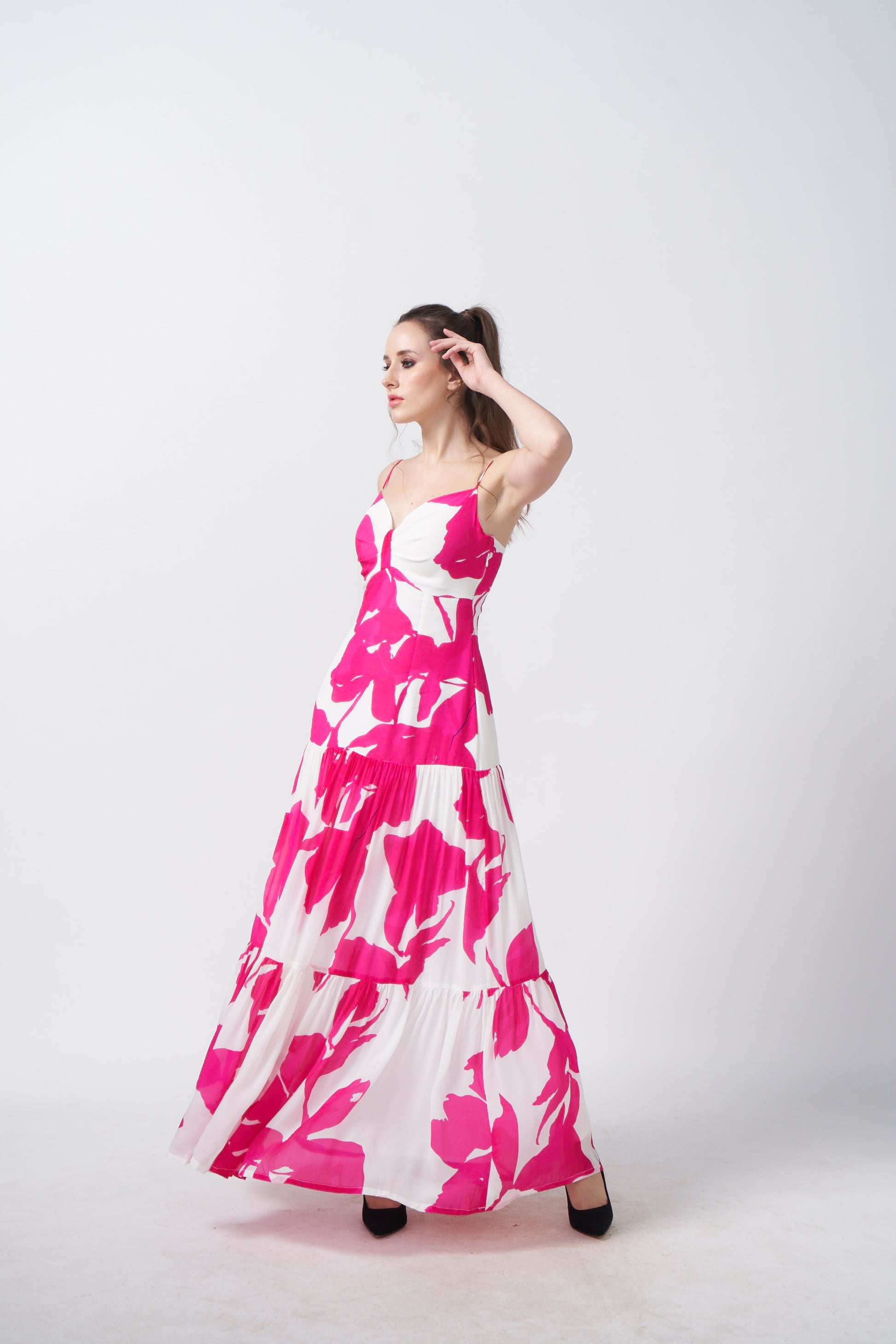 Side profile showcasing the silhouette and flow of the ruched pink floral dress.