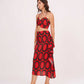 Model stepping forward with a subtle smile, displaying the ruched front crop top and bold abstract skirt print.
