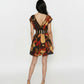 Back view of Mini V-neck dress featuring a striped waistband and geometric abstract print in warm earthy tones