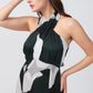 Close-up view of halter neckline and tie-back detail of satin abstract print dress.