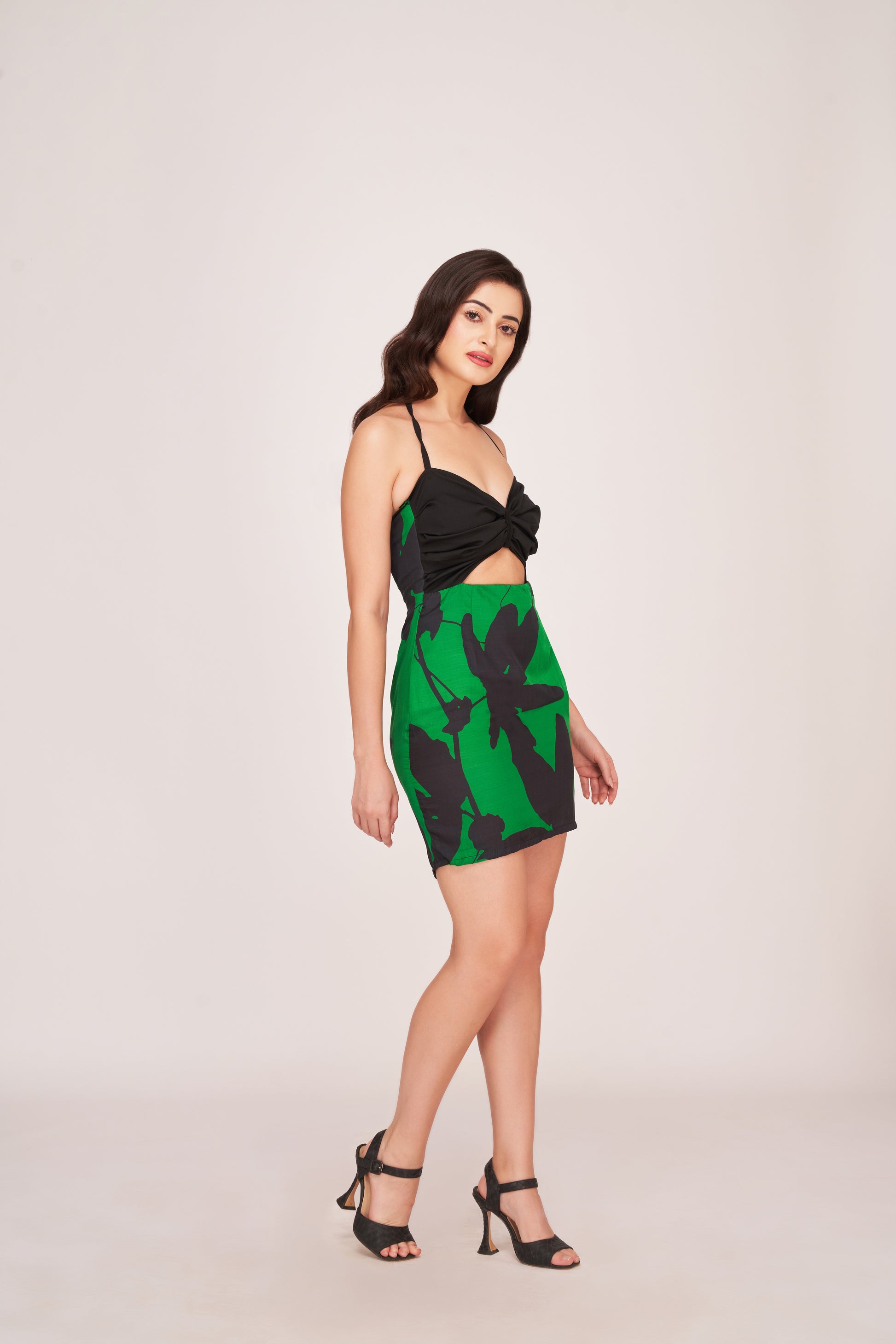 Two-tone construction combining a solid noir upper tier with a botanical print lower tier. The design offers a chic, body-hugging fit suitable for casual to semi-formal occasions.