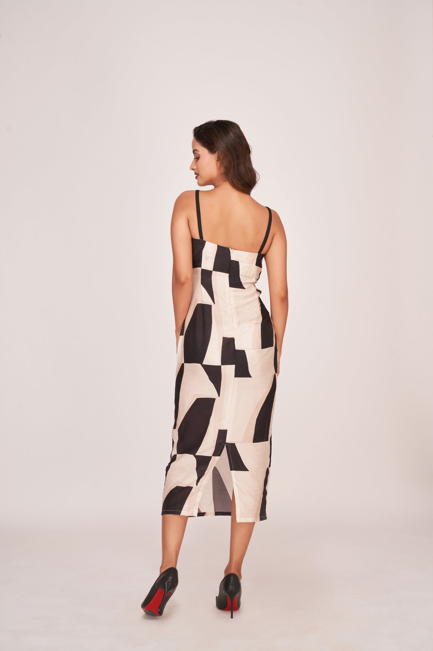Back view of a silk midi dress with shoulder straps, side cut-outs, and a back zip closure