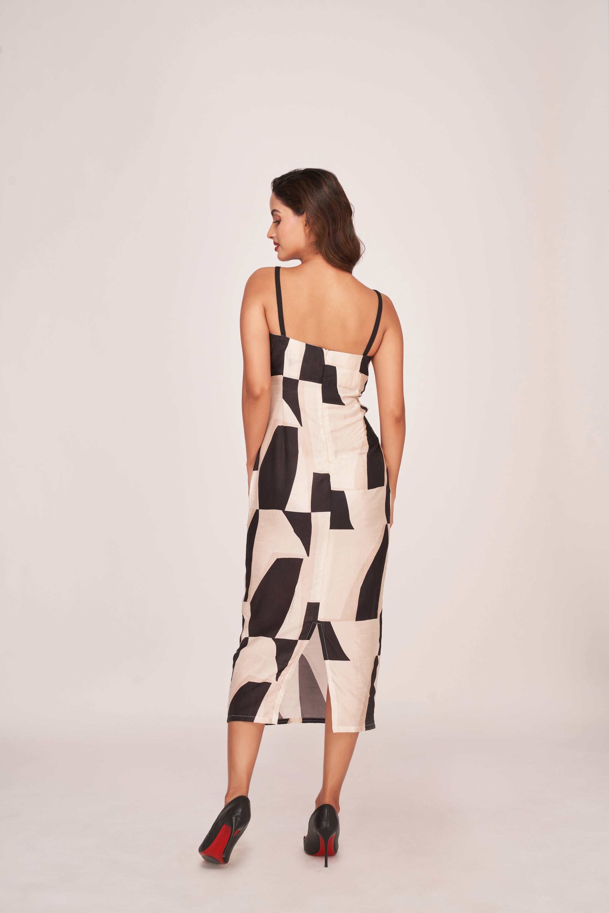 Back view of a silk midi dress with shoulder straps, side cut-outs, and a back zip closure
