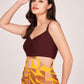 Side profile of the dress showing side cut-out detailing and the contrast between solid maroon top and abstract skirt.