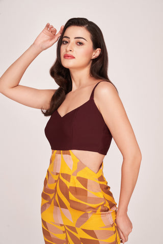 Side profile of the dress showing side cut-out detailing and the contrast between solid maroon top and abstract skirt.