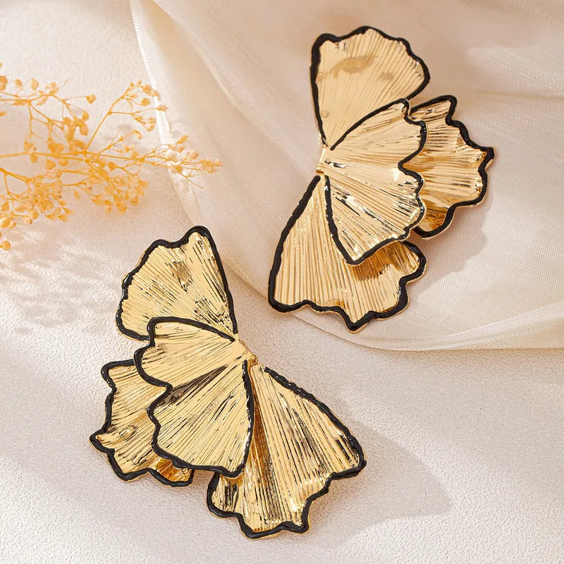 A pair of elegant gold-toned stud earrings designed to look like a cluster of delicate leaf petals, featuring a fine brushed texture that adds a sophisticated, matte-like shimmer to any outfit.