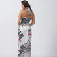Back view of model wearing satin halter dress with tie-back and wrap silhouette in grey floral print.