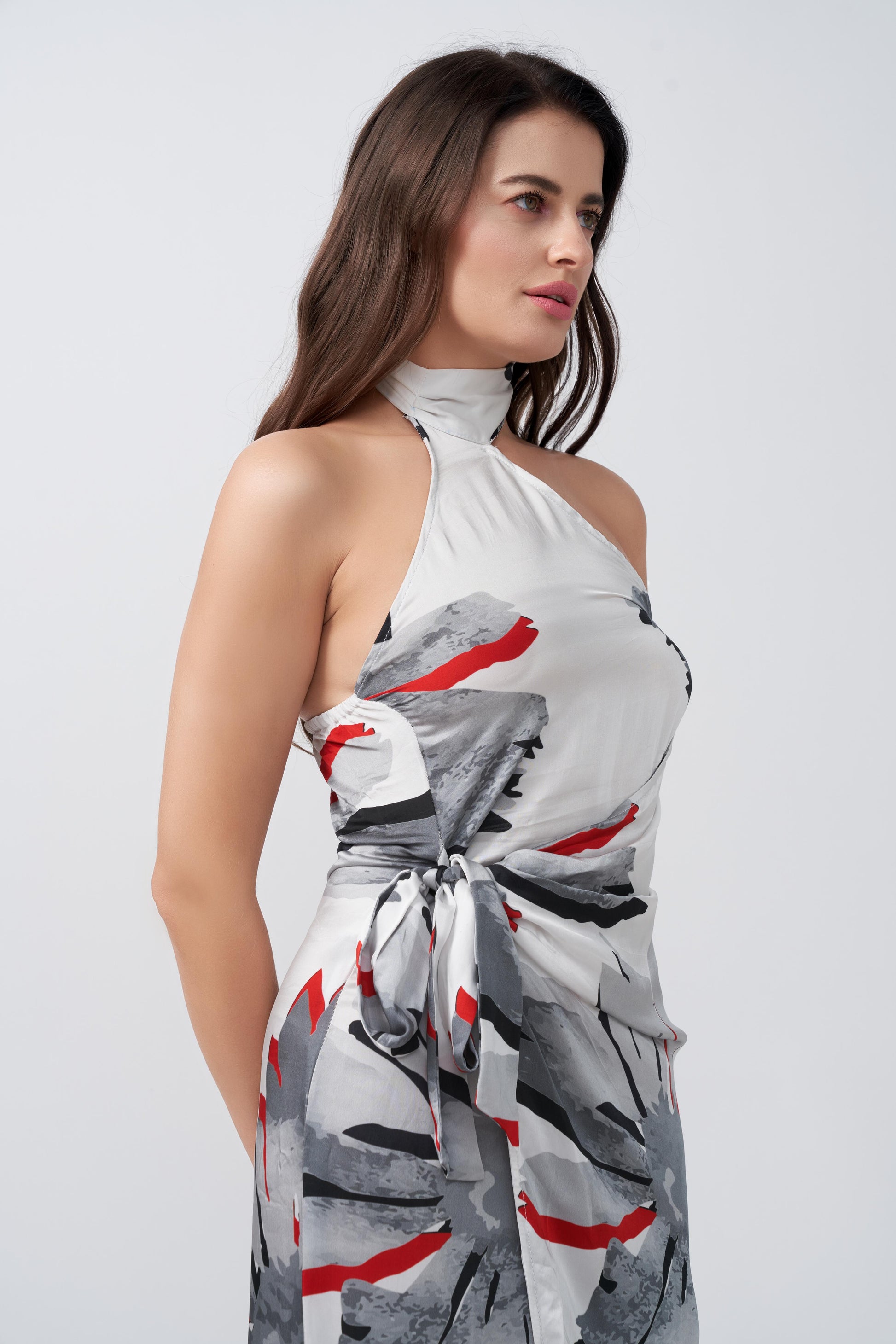 Close-up of model in grey and red floral satin wrap dress, highlighting halter neckline and wrap detailing.