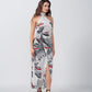  Side view of model walking in satin wrap dress featuring a grey floral print and subtle red accents.