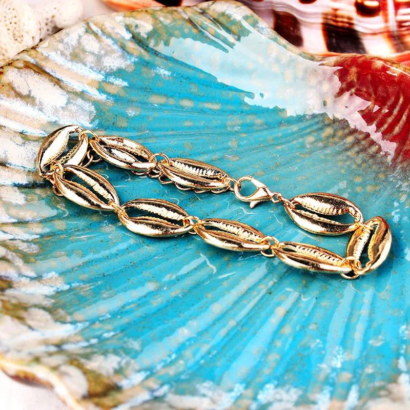 An elegant gold-toned shell anklet with a high-shine finish, an ideal accessory to add a touch of beachy glamour to your sunset dinner or vacation wardrobe.