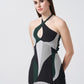 Side angle of model in sleeveless ankle-length dress with artistic green and grey patterns and tie-back neck.