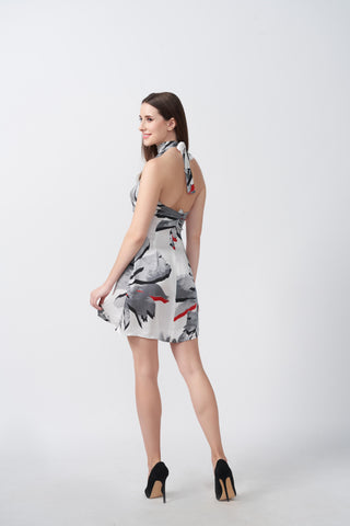 Back view of a short silk dress with a halter tie-back neckline and flowing fit