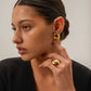 These sleek gold-toned oval studs offer a minimalist and sophisticated look that sits comfortably on the ear, making them an ideal accessory for a chic lunch date or a refined evening event.