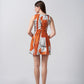 Backview of a model in bold burnt orange and white sleeveless short dress, showing clean lines and tailored fit.