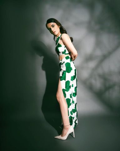  Model in relaxed standing stance with front slit visible, highlighting the skirt movement of the printed green co-ord.