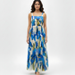 Blue floral maxi dress with a straight square neckline and slim shoulder straps, designed for refined evening occasions.