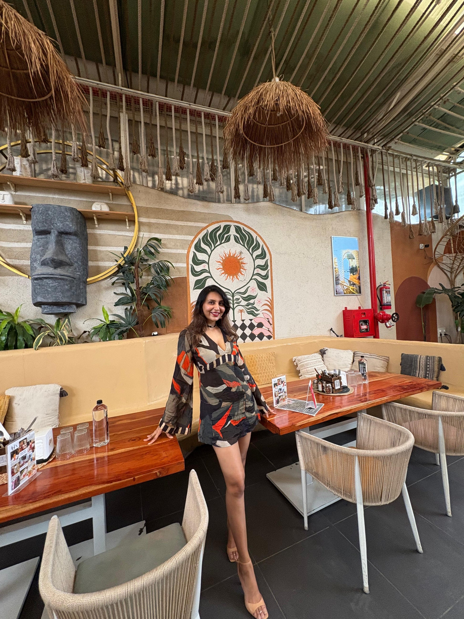 Mini dress with a deep V-neckline, long billowing sleeves, and a multicolored abstract print in earthy and vibrant tones