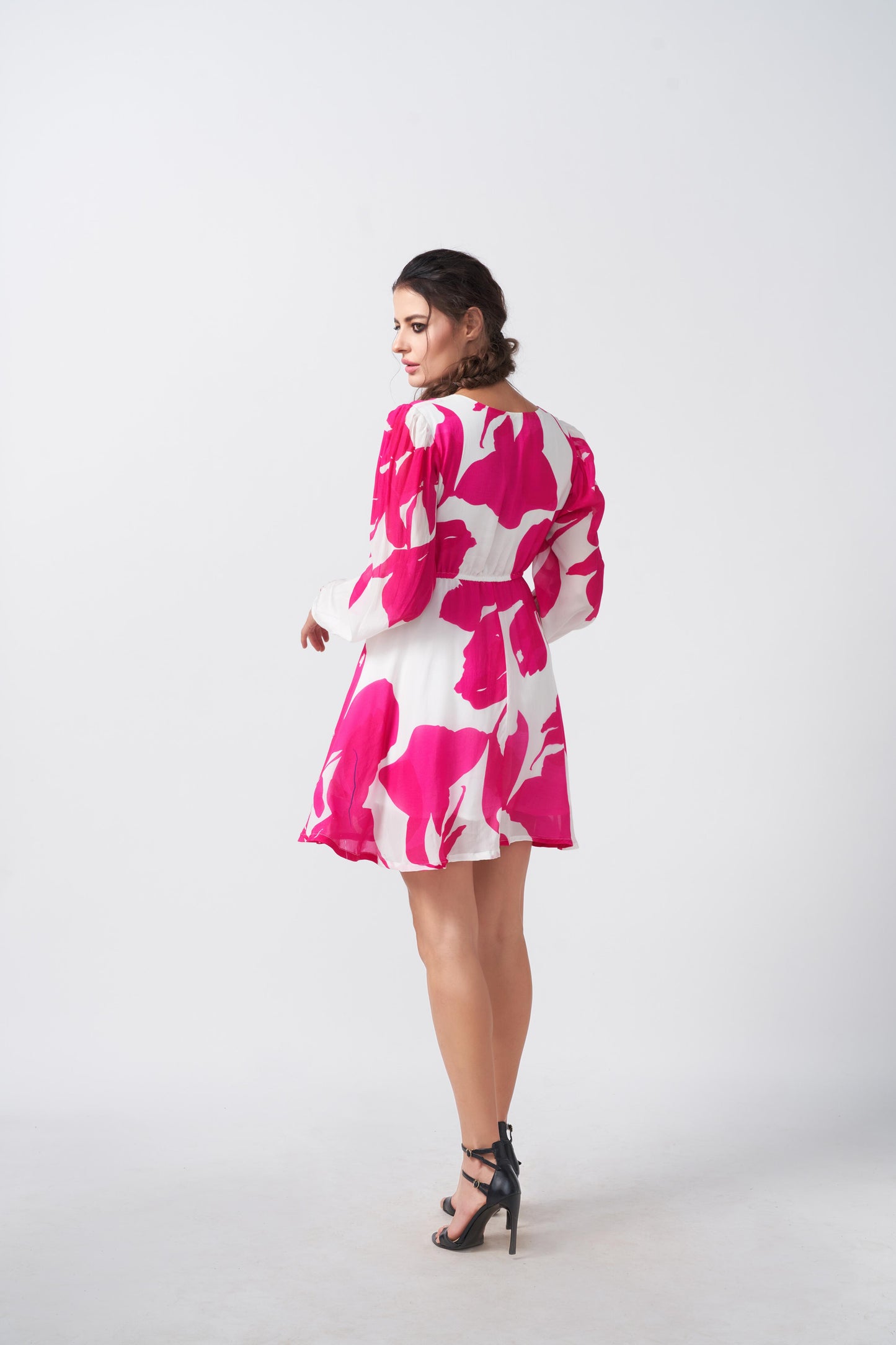 Back view of a short crepe dress with balloon sleeves and a flowing silhouette