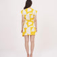 Rear view of the yellow printed wrap dress, showcasing the back tie closure and sleeveless shoulder cut.