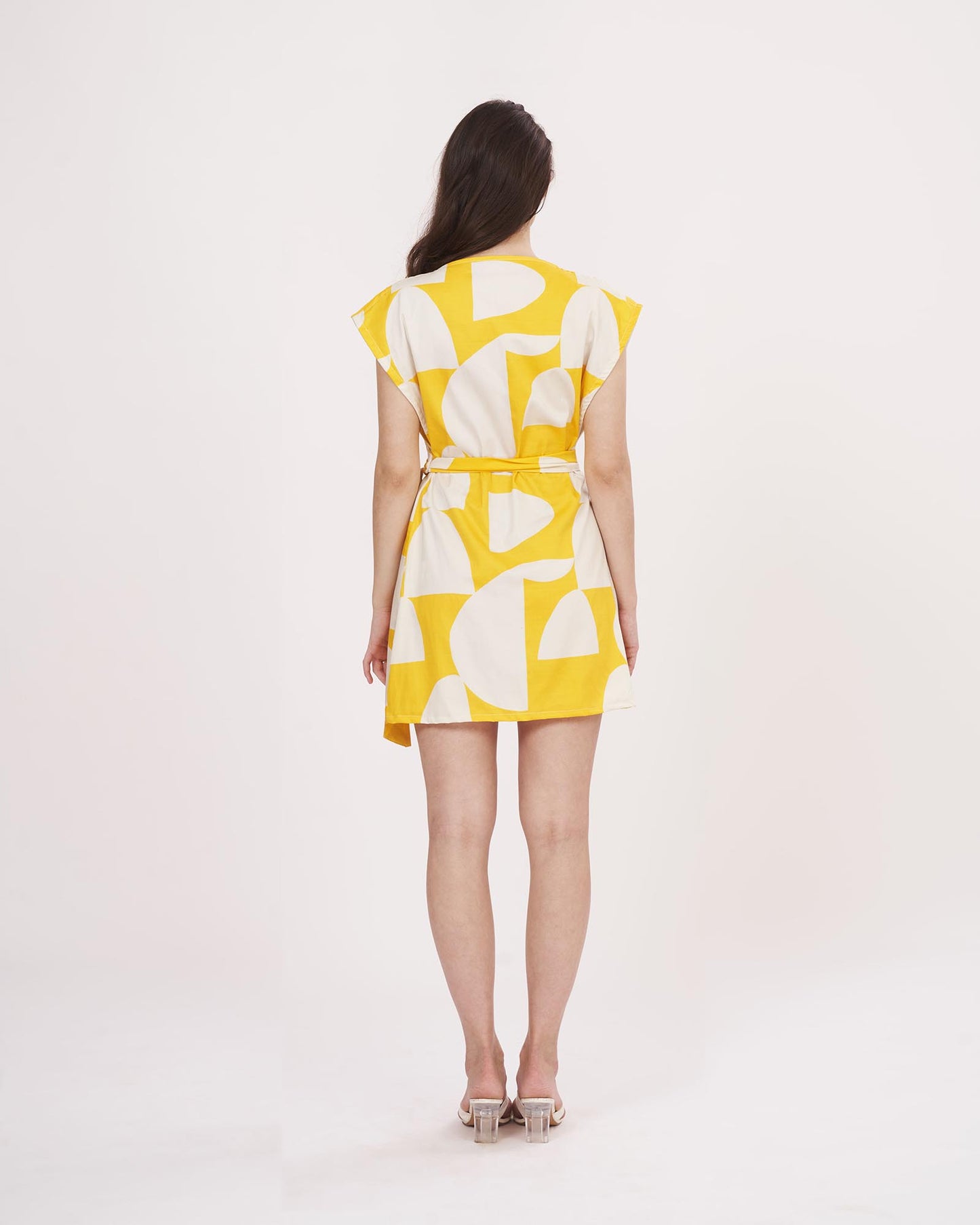 Rear view of the yellow printed wrap dress, showcasing the back tie closure and sleeveless shoulder cut.