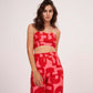 Graphic print ensemble in vibrant red hues, combining a fitted bodice with relaxed flowy bottoms for a chic look.