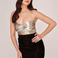 Full-body shot of model in silver and black ruched dress with strap shoulders and sleek silhouette.