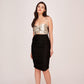 Angled pose of model smiling in silver and black sweetheart neck dress with flattering ruched finish.