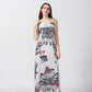 Model wearing ankle-length satin dress with white and grey floral print and spaghetti straps, standing front-facing.