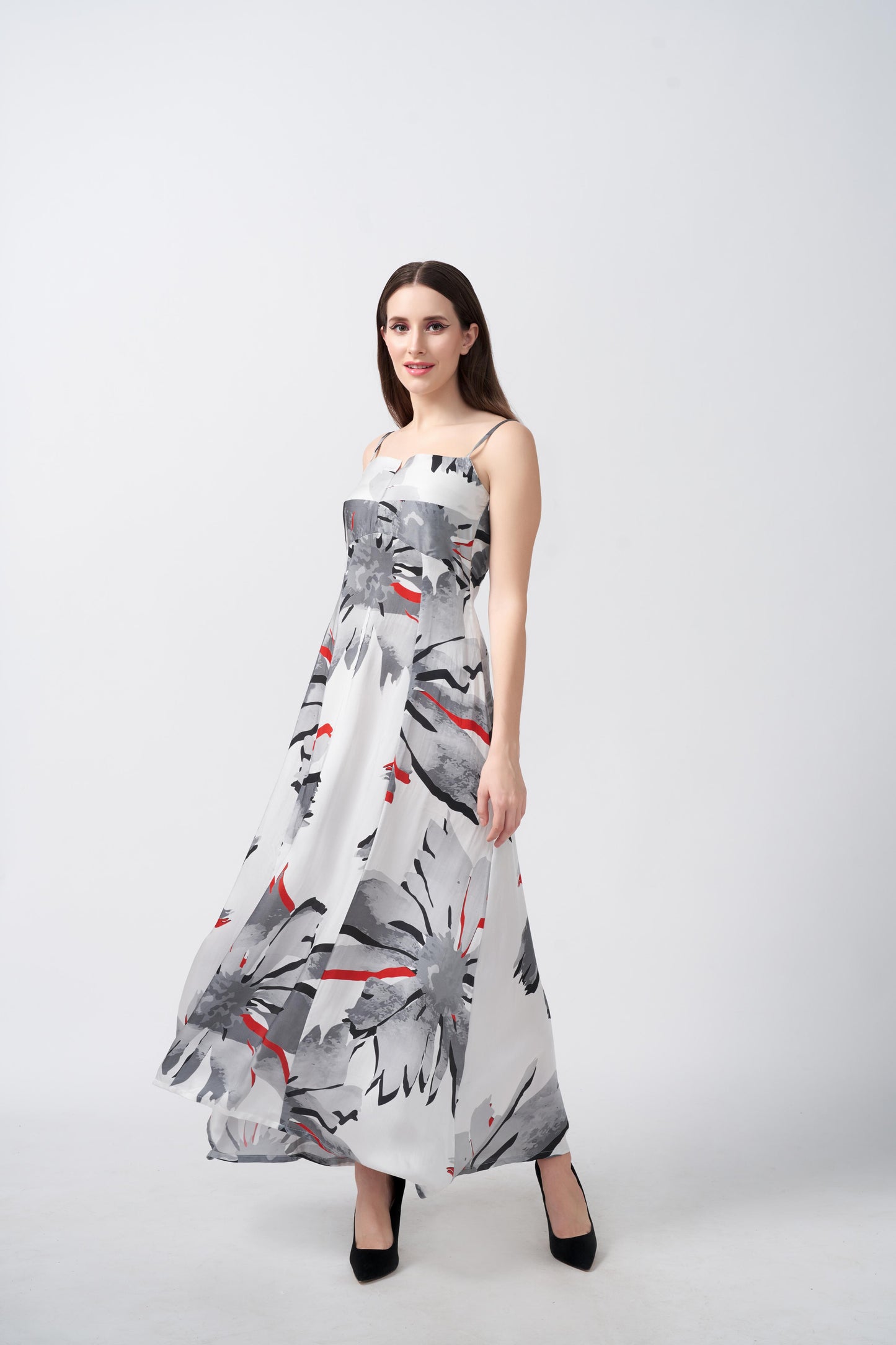Model in a relaxed stance wearing grey floral ankle-length dress with a hint of red and a clean, modern finish