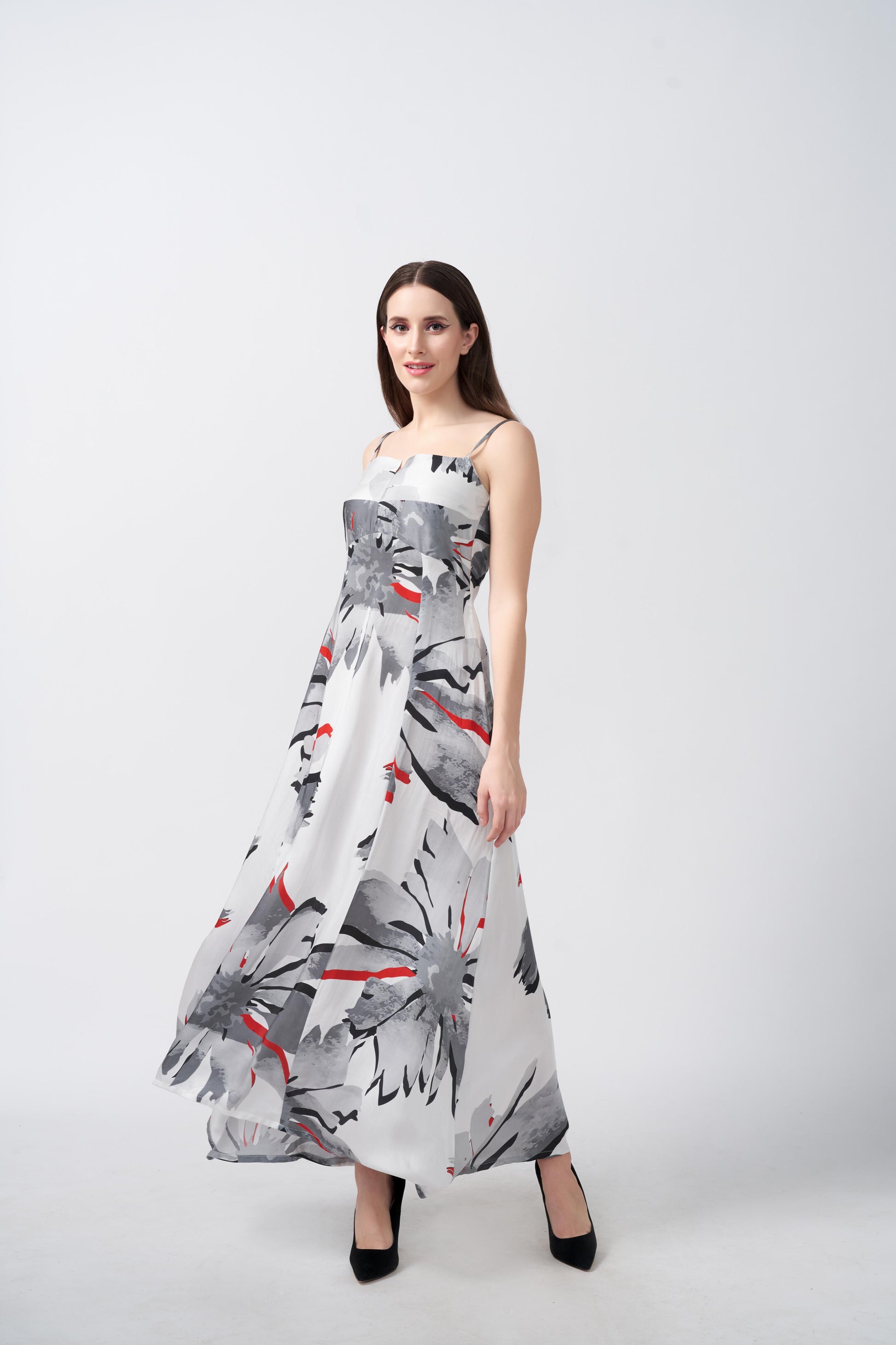 Model in a relaxed stance wearing grey floral ankle-length dress with a hint of red and a clean, modern finish