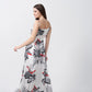Side view of model walking in elegant satin floral dress with spaghetti straps and modern silhouette.