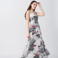 Model twirling in a flowy ankle-length satin dress with square neckline and red-accented floral design.