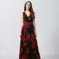 Front view of model in full-length orange and black abstract floral dress with V-neck.