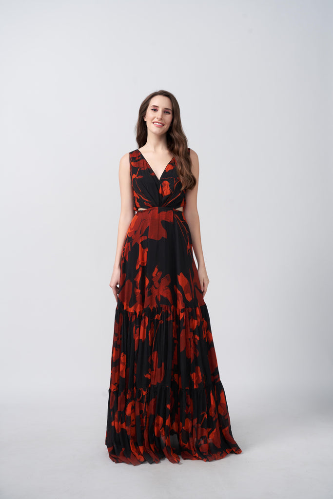 Front view of model in full-length orange and black abstract floral dress with V-neck.
