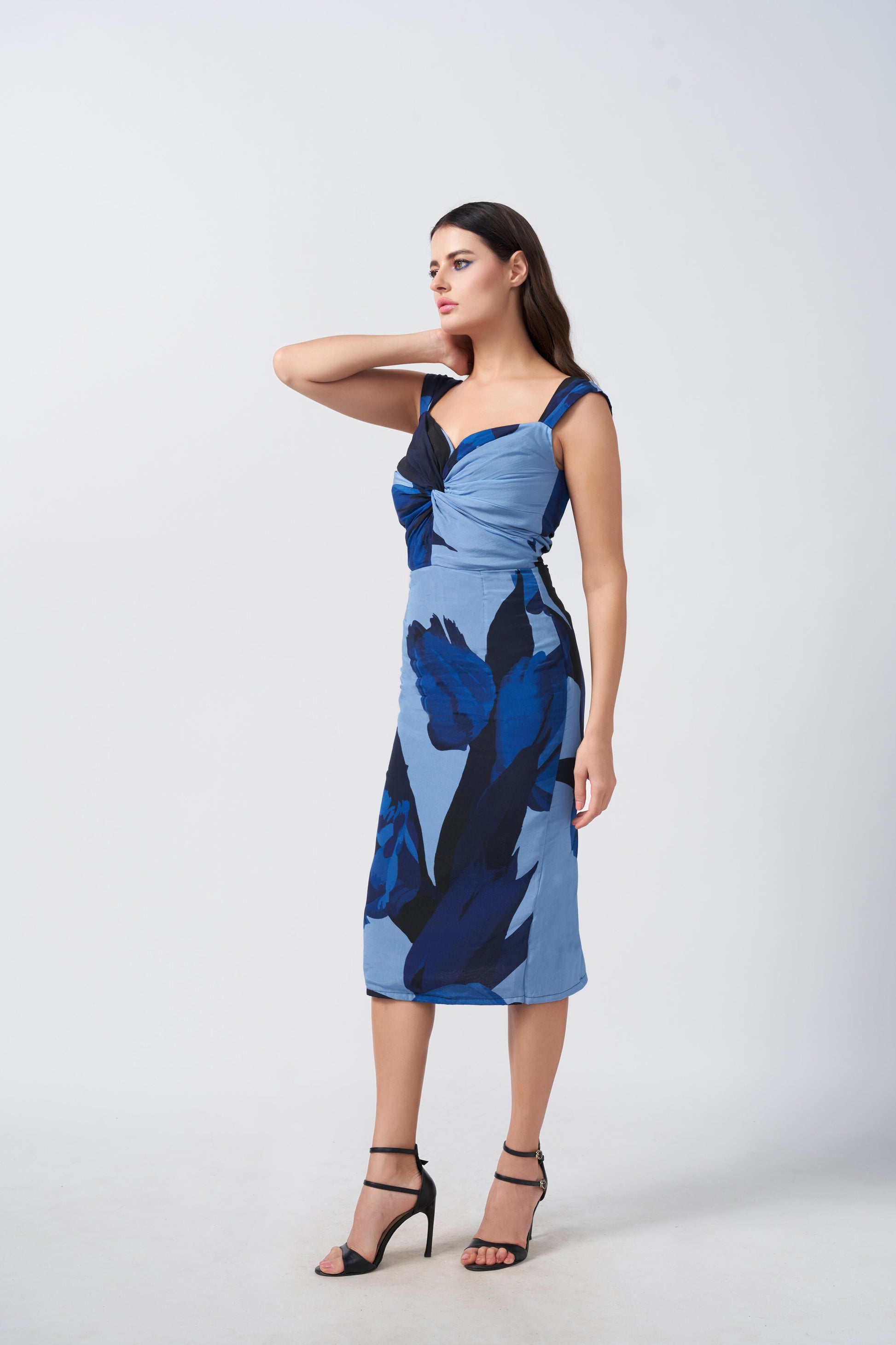 Full-body side profile of the model in light and dark blue floral midi dress, highlighting the dress’s flow and midi length.