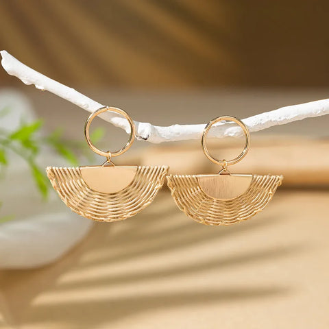 Gold half-circle rattan earrings with a woven straw texture and metallic gold hoop, ideal for a bohemian or vacation look.
