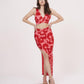 Hands-on-waist pose highlighting the deep V-neck and slit placement on the red printed skirt set.