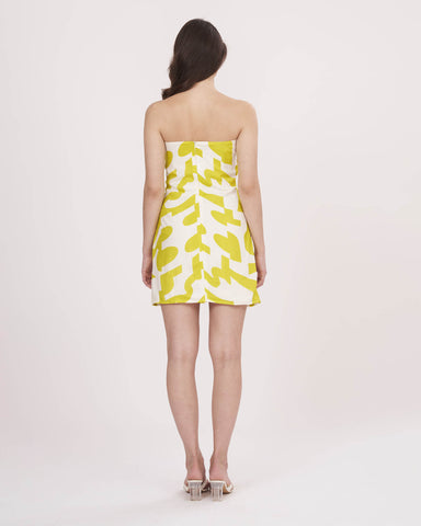 Back view of the model in yellow tube dress, focusing on the zip closure and clean finish.