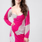 Woman wearing a pink and white abstract print ankle-length dress, standing with her one hand on her waist