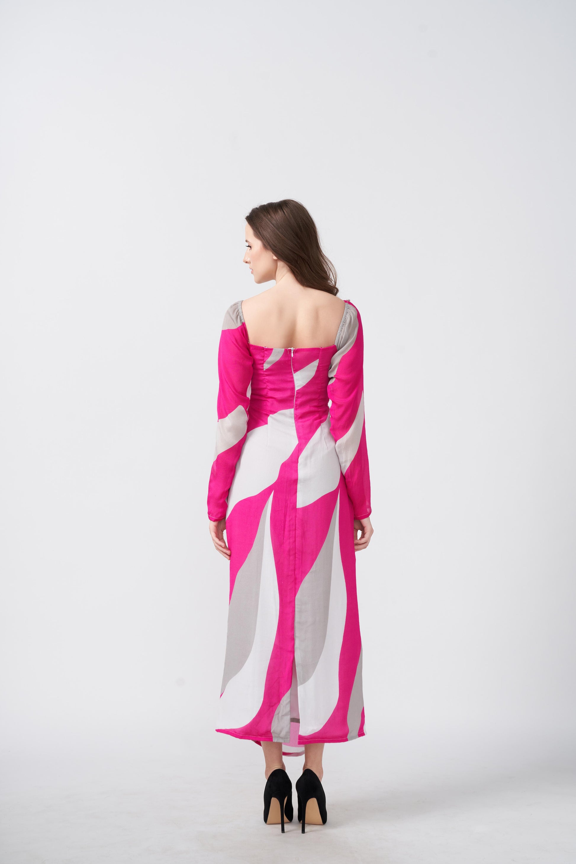 Backview of a woman modeling a pink and white abstract print ankle-length dress, 