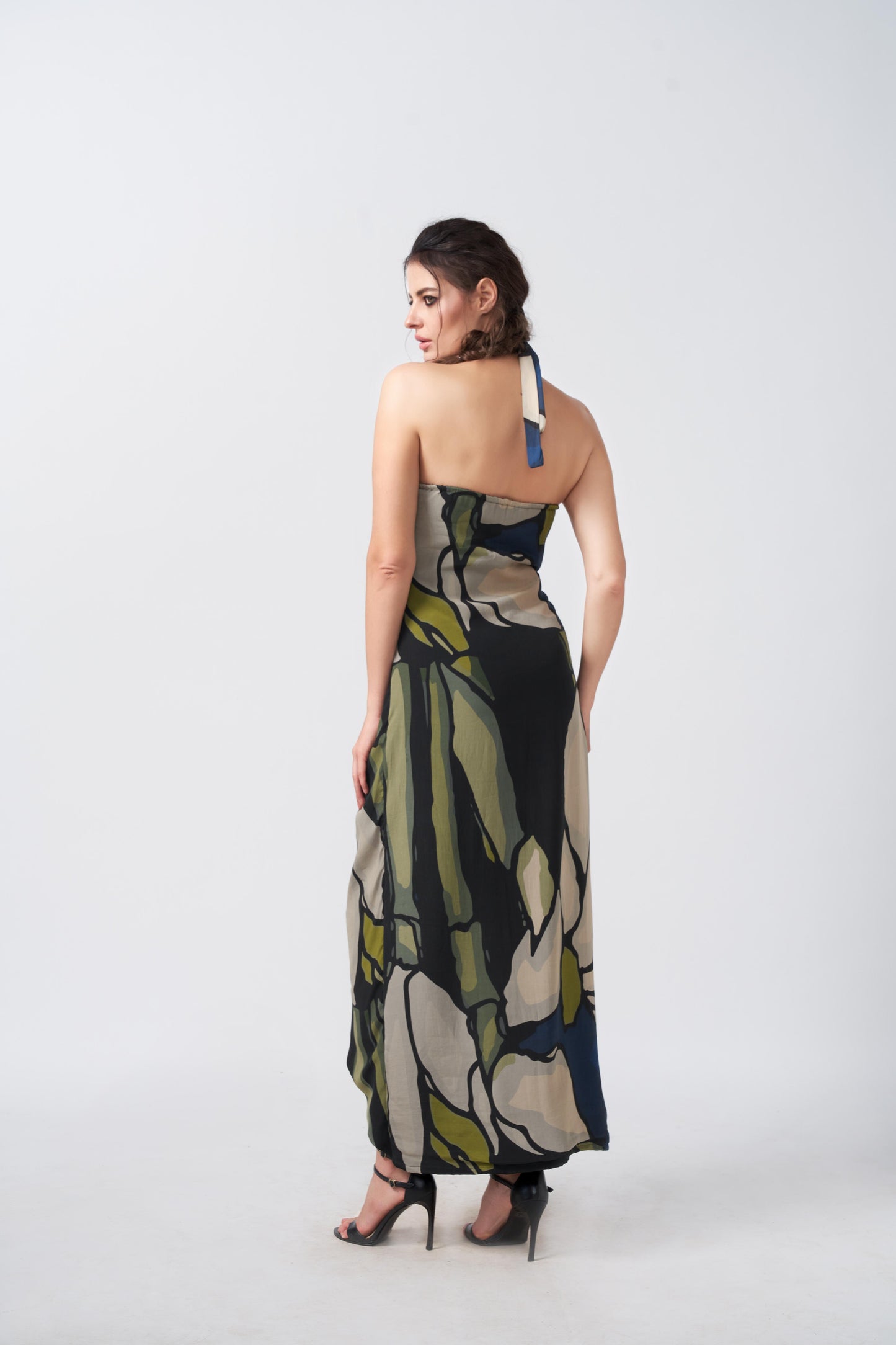 Model showing back view of navy and beige wrap dress featuring tie-back halter neck and side waist tie.