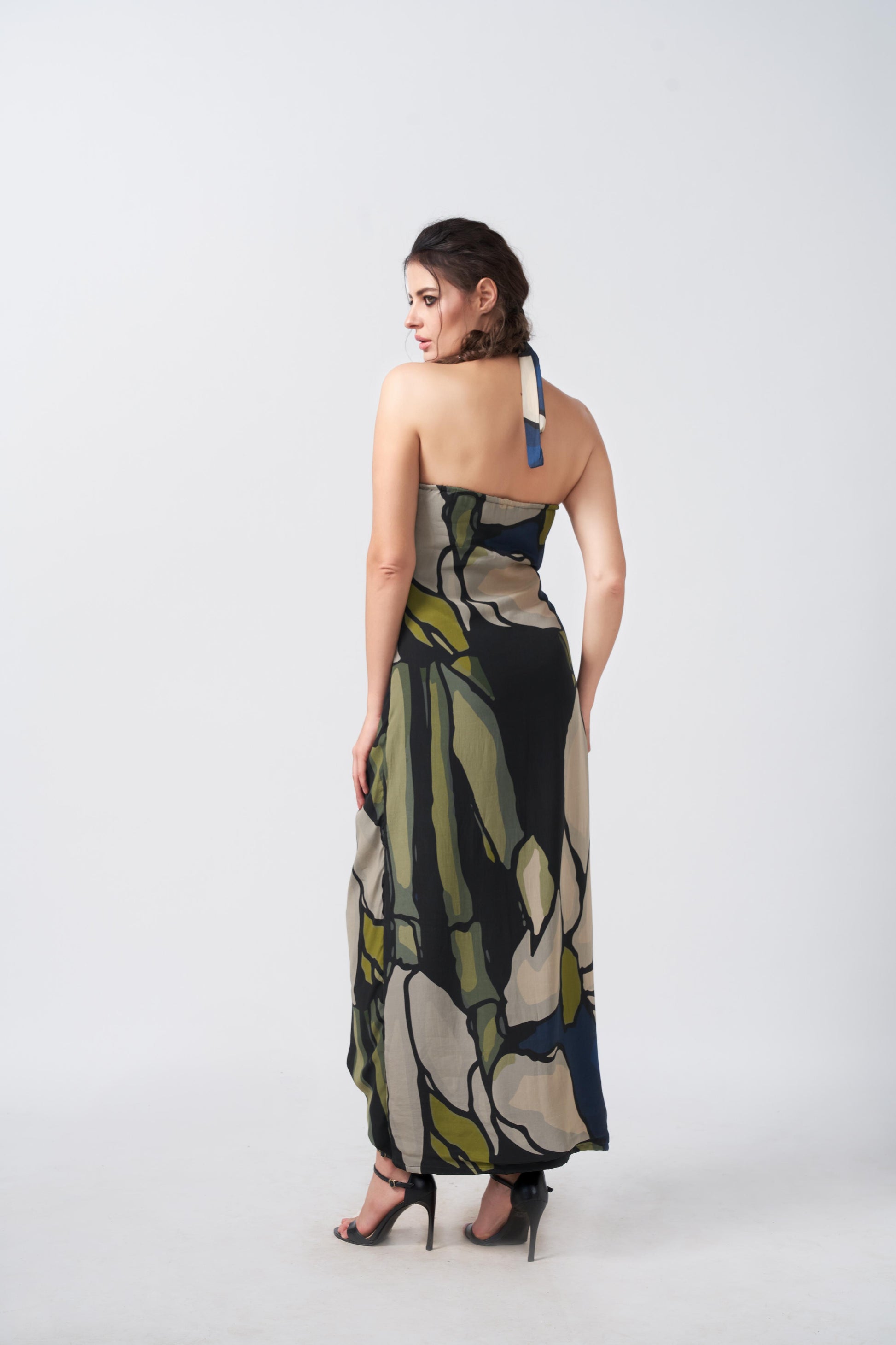 Model showing back view of navy and beige wrap dress featuring tie-back halter neck and side waist tie.