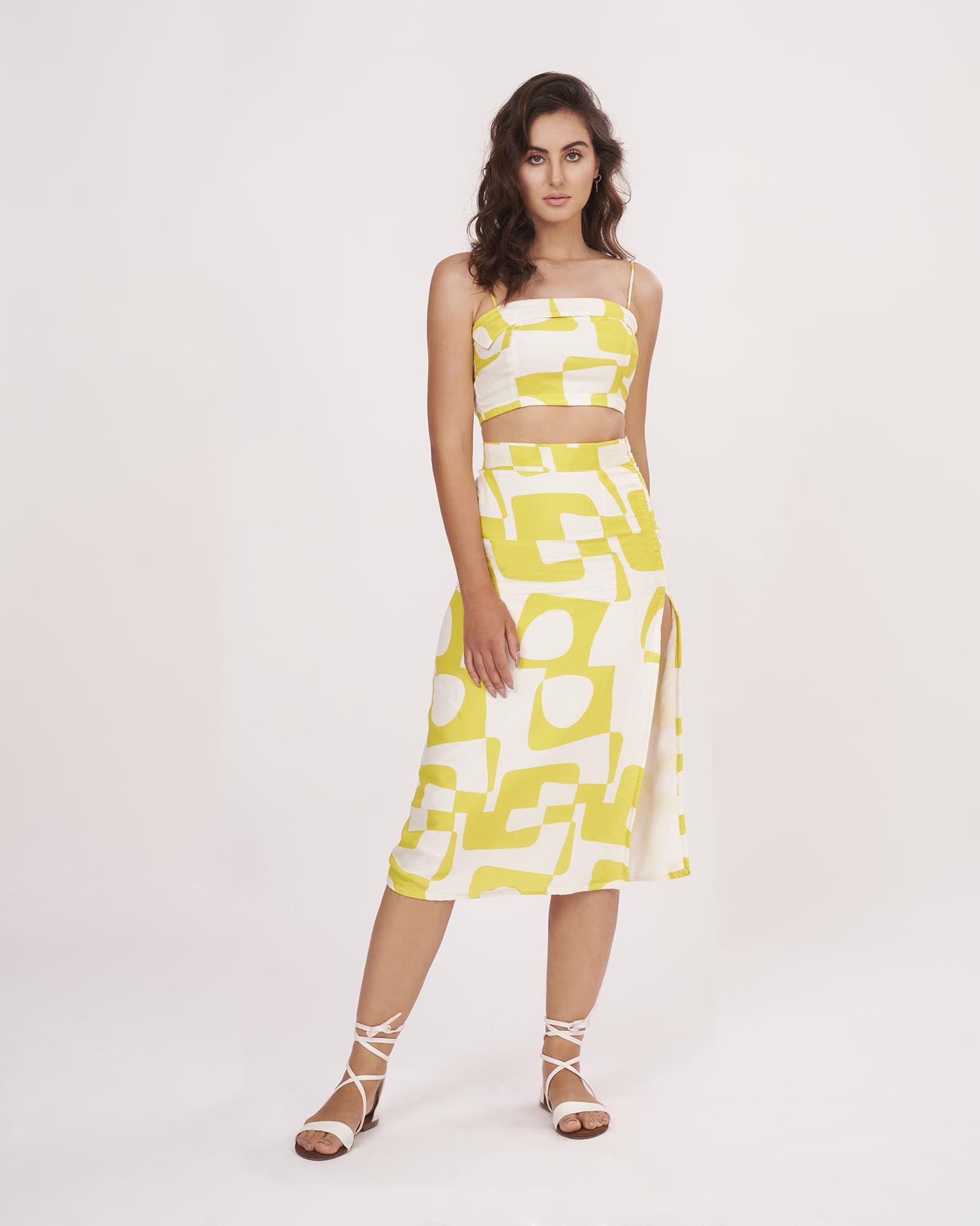 Full front view of the yellow co-ord set with square-neck strappy top and high-slit skirt, emphasizing the clean silhouette and bold print.