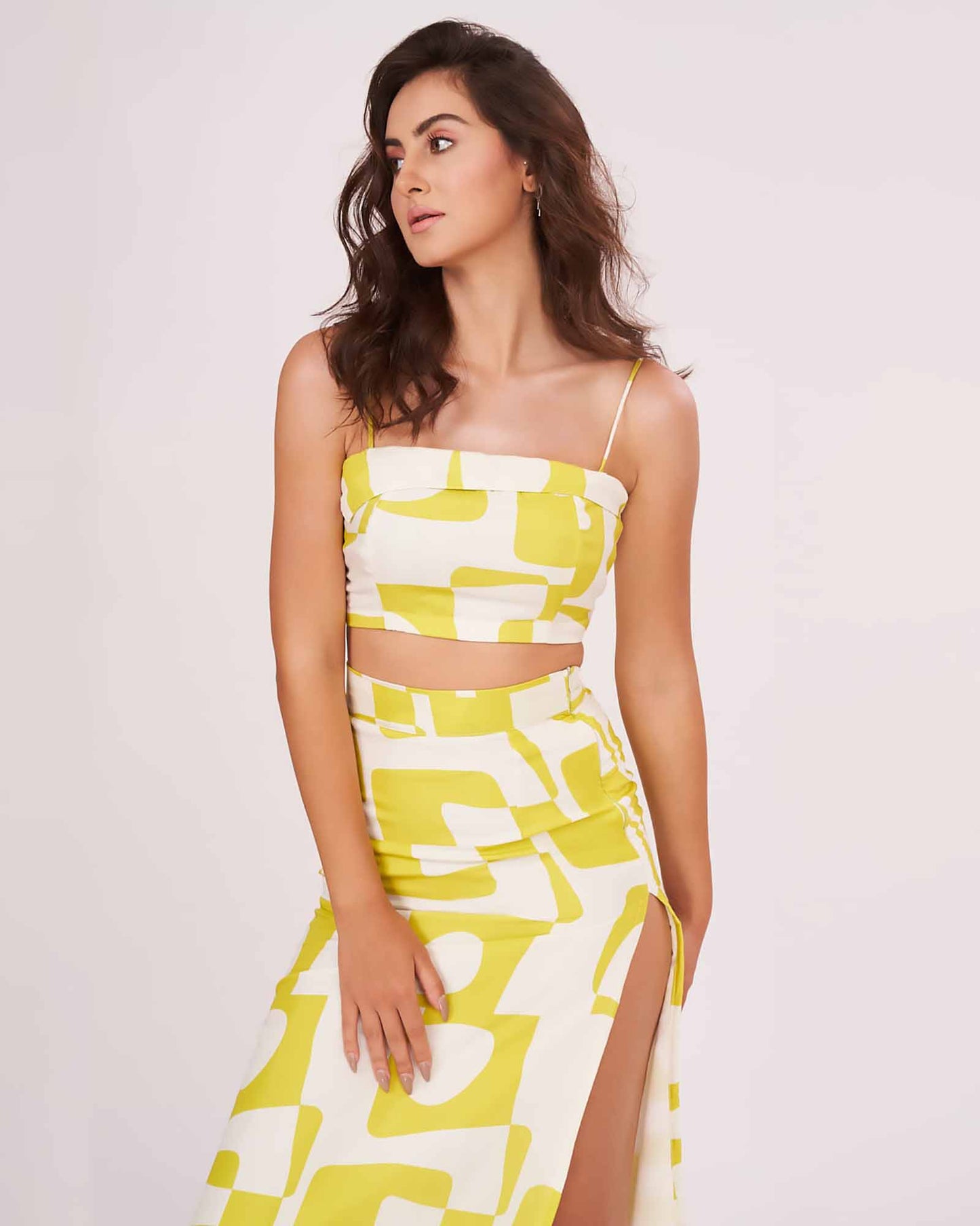 Model in a walking pose, turning slightly to the side, showcasing the breezy fit and movement of the printed muslin skirt and strappy top.