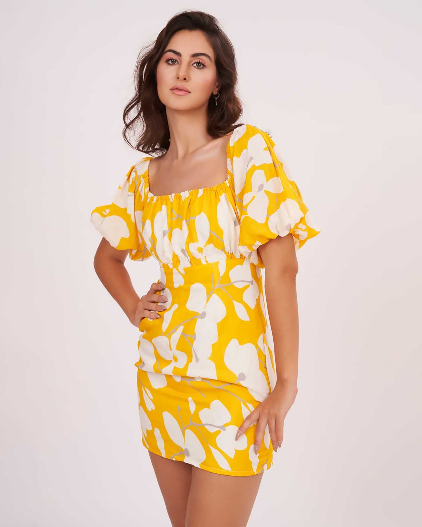 Model in mid-angle pose with one hand on waist, highlighting corset neckline and vibrant floral print.