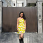 Influencer walking in yellow tube dress, reflecting a chic city-resort blend.